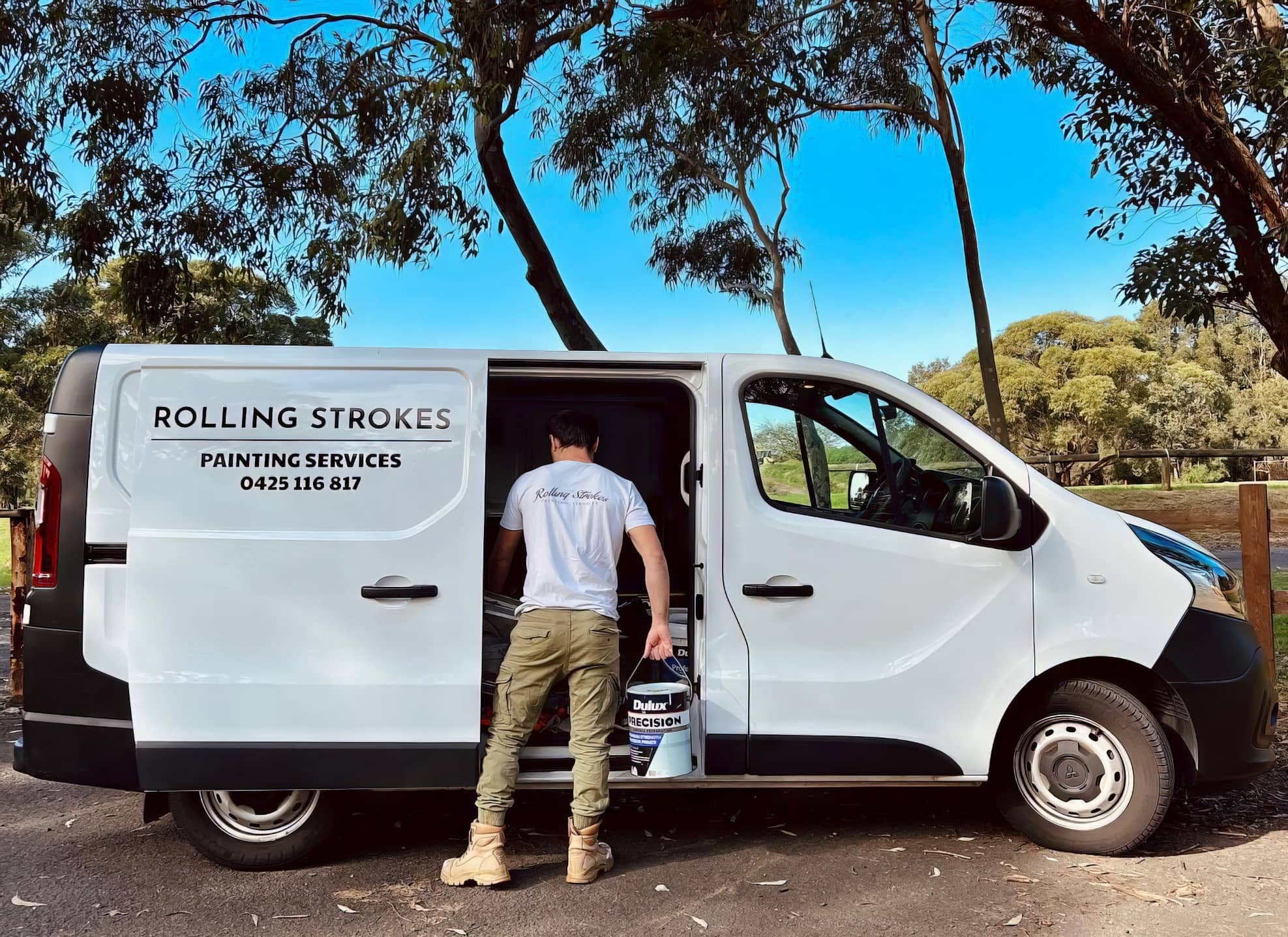 Rolling Strokes team member loading paint into the branded company van